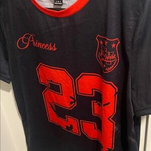 Runs a little big would look cute with a black skirt with red bows on the back